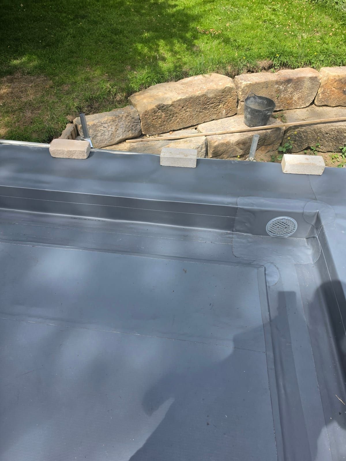 Fatra PVC upstands and a through-wall outlet with a leaf guard in the corner of a new garage roof
