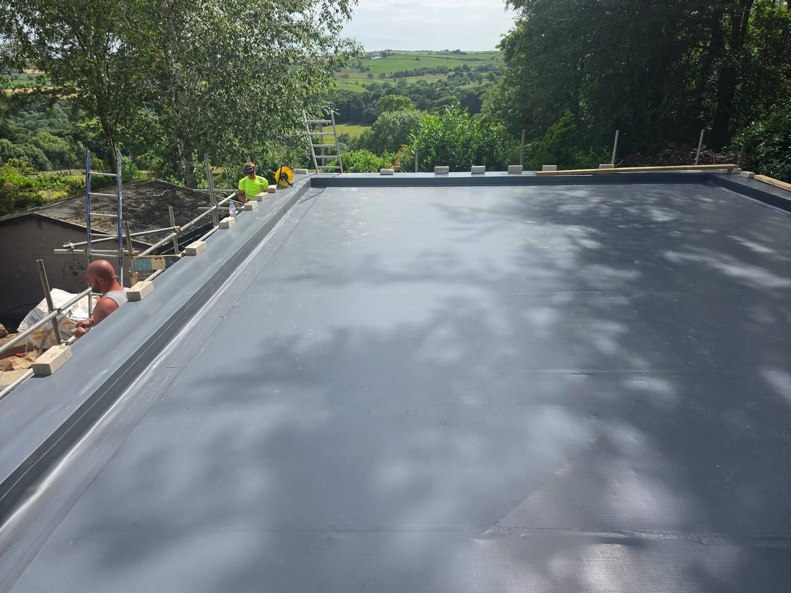 Dark grey single ply membrane installed on the garage roof before the sedum layer