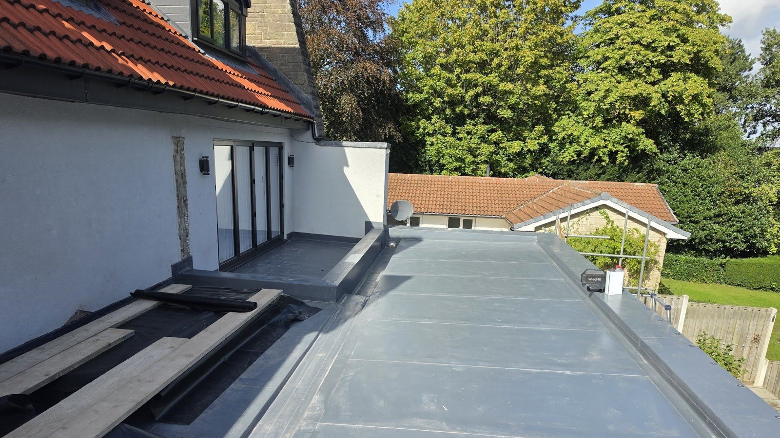 Grey Fatra PVC single ply roof on a house extension at Thornset Gardens, with welded upstands to the walls and the balcony